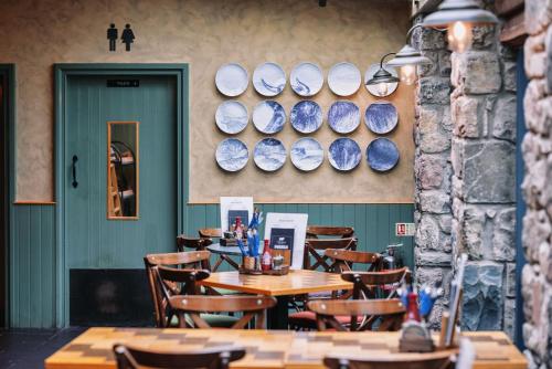 a restaurant with tables and chairs and plates on the wall at The Bull and Townhouse, Beaumaris- The Inn Collection Group in Beaumaris