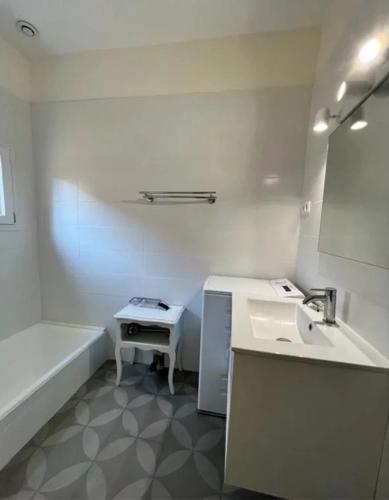 une salle de bain avec un lavabo, une baignoire et un miroir dans l'établissement Moli Pêcheur, à Valras-Plage