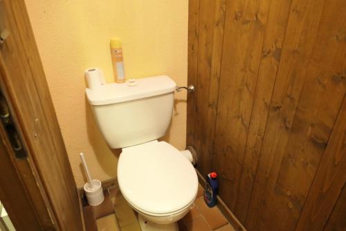 ein weißes WC im Bad mit einer Holztür in der Unterkunft Résidence La Gelinotte - 3 Pièces pour 6 Personnes 60 in Saint-Gervais-les-Bains