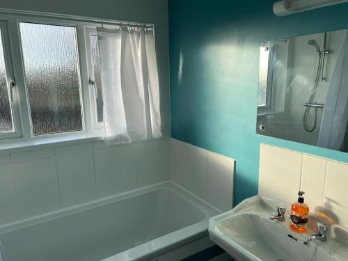 a bathroom with a sink and a shower and a mirror at Maple House a spacious 2 Bedroom House in Barnstaple