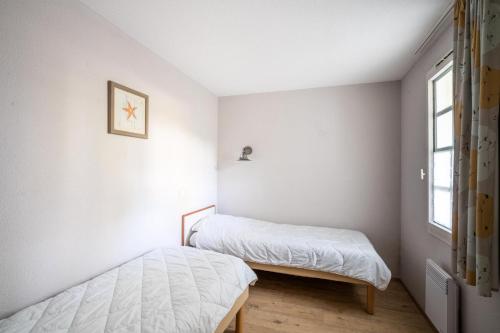 a bedroom with two beds and a window at Le Cap Glénan - maeva Home - 2 Pièces 5 Personnes Confort MAE-5645 in Bénodet