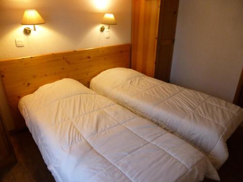 - une chambre avec un lit avec des draps blancs et deux lumières dans l'établissement Résidence Le Grand Panorama - Grand Panorama 115 MAE-5286, à Saint-Gervais-les-Bains