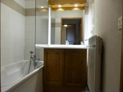 une salle de bain avec une baignoire, un lavabo et un miroir dans l'établissement Résidence Le Grand Panorama - Grand Panorama 115 MAE-5286, à Saint-Gervais-les-Bains