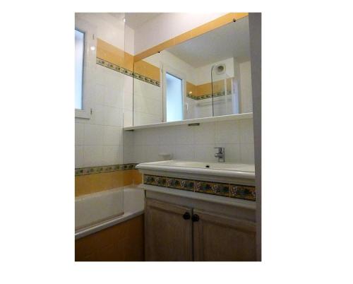 une salle de bain avec un lavabo, une baignoire et un miroir dans l'établissement Les Appartements aux Restanques du Golfe de St Tropez - maeva Home - Appartement belle vue mer à 180° pour 5 Personnes - Sélection MAE-5607, à Grimaud