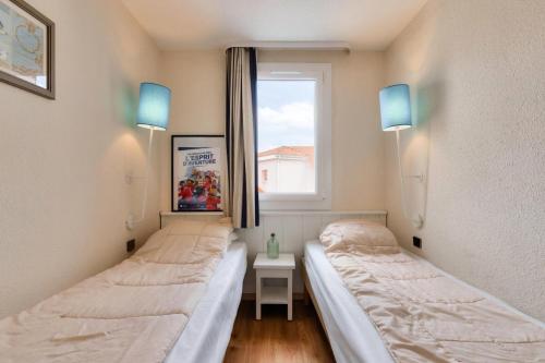deux lits dans une chambre avec une fenêtre dans l'établissement Résidence Port Bourgenay - maeva Home - Appartement 2 pièces 4 personnes avec vue lac - Sélection - Super Home MAE-5651, à Talmont-Saint-Hilaire