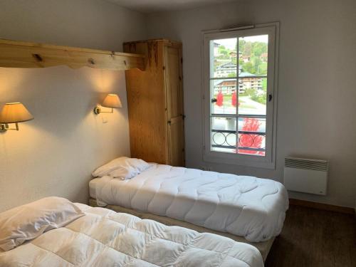 deux lits dans une chambre avec une fenêtre dans l'établissement Résidence Le Grand Panorama - Grand Panorama 402 MAE-5297, à Saint-Gervais-les-Bains