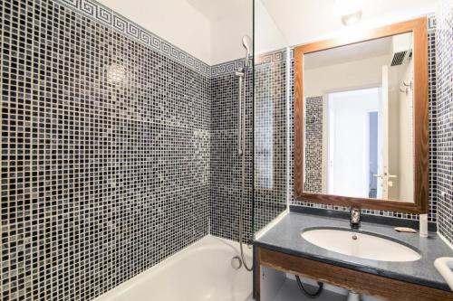ein Badezimmer mit einem Waschbecken, einer Badewanne und einem Spiegel in der Unterkunft Résidence le Hameau de Cap Esterel - maeva Home - Appartement 2 Pièces 7 Pe 20 in Saint-Raphaël