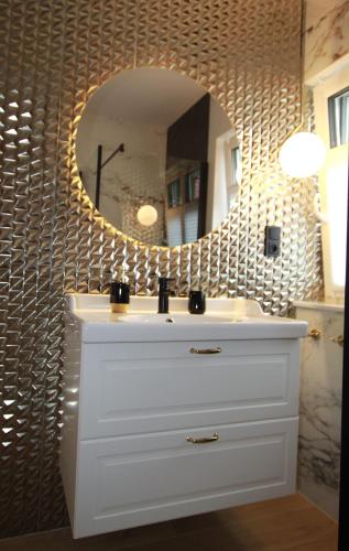 a bathroom with a white sink and a mirror at Grand Royal Baltic Ustka - luksusowy Apartament 150 metrów od plaży, port, zielony taras, bezpłatny parking, top lokalizacja w centrum Ustki in Ustka