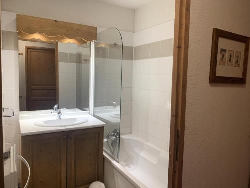 une salle de bain avec un lavabo, une baignoire et un miroir dans l'établissement Résidence Le Grand Panorama - Grand Panorama 202 MAE-5294, à Saint-Gervais-les-Bains