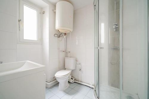 une salle de bain blanche avec toilettes et douche dans l'établissement Studio Voltaire - 2G - III, à Paris