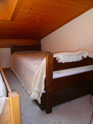 un lit dans une chambre avec un plafond en bois dans l'établissement Résidence Les OrÉades - Oréades 15 MAE-5320, à Combloux