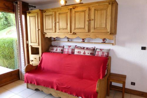 - un lit rouge dans une chambre avec fenêtre dans l'établissement Résidence Gros Cailloux Amethyste - Gros Cailloux A7 MAE-5328, à Combloux