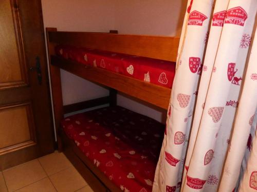 Cette chambre comprend un lit avec des rideaux à côté d'une porte. dans l'établissement Résidence Gros Cailloux Amethyste - Gros Cailloux A7 MAE-5328, à Combloux