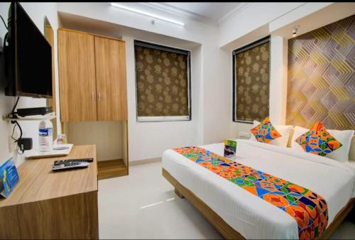 Dormitorio con cama, escritorio y TV en ESTA EXPRESS,VIMAN NAGAR, en Pune