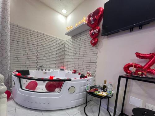 La salle de bains est pourvue d'une baignoire avec des ballons rouges. dans l'établissement Spazio Relax B&B, 