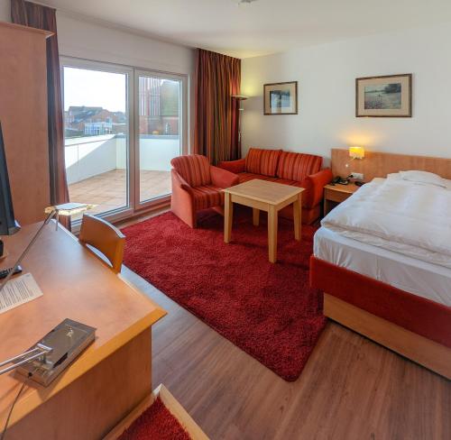 a hotel room with a bed and a living room at Hotel Flörke in Langeoog