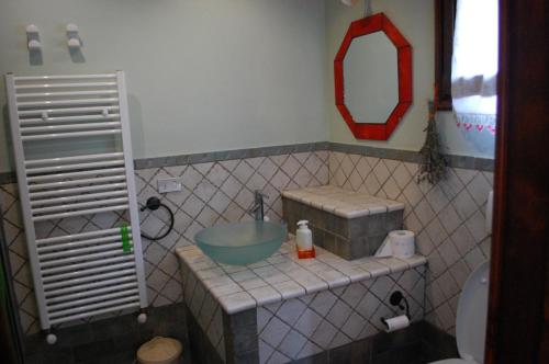 y baño con lavabo y espejo. en Il Pino en Vetulonia