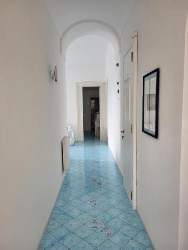 卡普里的住宿－LA PANORAMICA 55，大楼内带蓝色瓷砖地板的走廊
