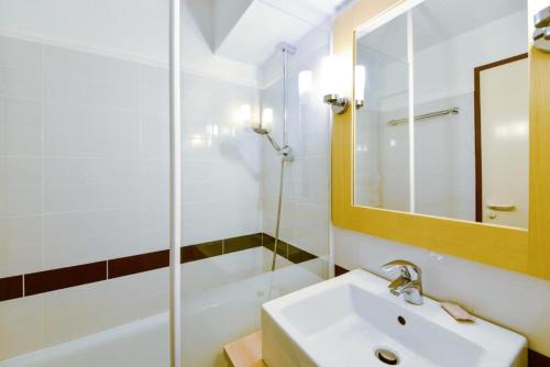 une salle de bain blanche avec un lavabo et une douche dans l'établissement Résidence Port du Crouesty - maeva Home - Studio 5 Personnes - Sélection - Vue Mer MAE-6831, à Arzon