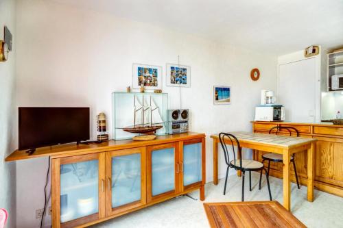un salon avec une table et une télévision dans l'établissement Résidence Mané Vihan proche de la plage - maeva Home - Appartement 2 Pièces 4 Personnes Budget MAE-7335, à Arzon