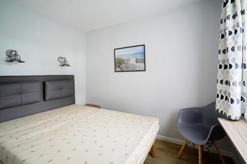 une chambre avec un lit, un bureau et une chaise dans l'établissement Le Cap Glénan - maeva Home - Appartement 2 Pièces 5 Personnes - Sélection MAE-7427, à Bénodet