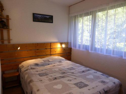Schlafzimmer mit einem Bett und einem Fenster in der Unterkunft Résidence Rochasset - 3 Pièces pour 6 Personnes 45 in Les Contamines-Montjoie