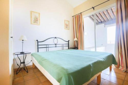 une chambre avec un lit et une grande fenêtre dans l'établissement Les Bastides aux Restanques du Golfe de St Tropez - maeva Home - Bastide pour 6 personnes belle vue sur la Baie MAE-7833, à Grimaud