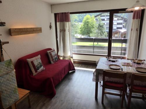 un salon avec un canapé rouge et une table dans l'établissement Résidence Le Brulaz - Brulaz F1E MAE-5347, aux Contamines-Montjoie