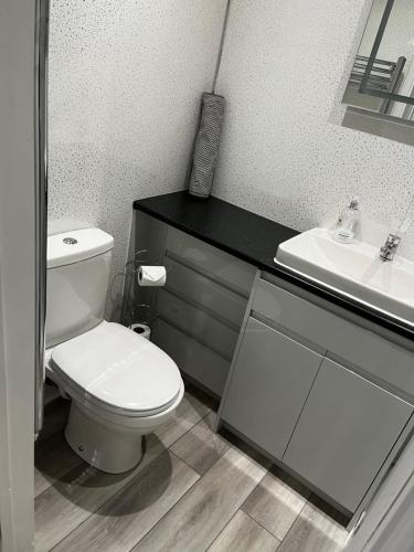 a bathroom with a white toilet and a sink at The Cosy Nook in Redruth