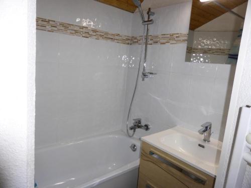 a white bathroom with a tub and a sink at Résidence Combettes - 2 Pièces pour 5 Personnes 52 in Les Contamines-Montjoie