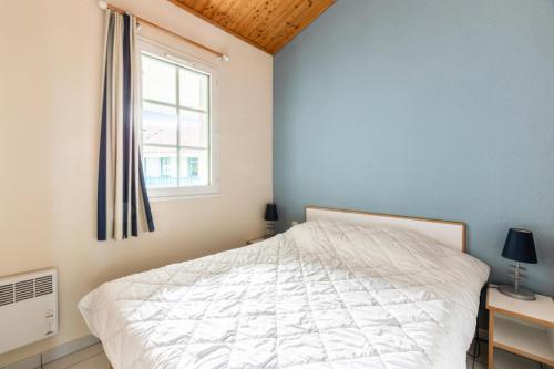 une chambre avec un lit blanc et une fenêtre dans l'établissement Résidence Port Bourgenay - maeva Home - 3 Pièces 7 Personnes Sélection MAE-7834, à Talmont-Saint-Hilaire