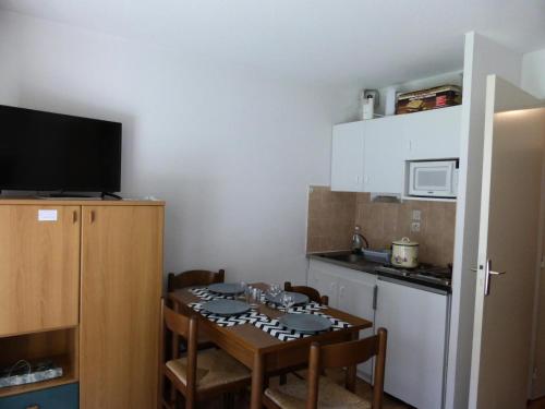 Il comprend une petite cuisine avec une table, des chaises et un four micro-ondes. dans l'établissement Résidence L'enclave - Enclave I638 MAE-5354, aux Contamines-Montjoie