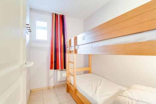 une chambre avec deux lits superposés et une fenêtre dans l'établissement Village Moliets - maeva Home - 2 Pièces 5 Personnes Confort MAE-7861, à Moliets-et-Maa