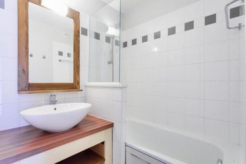 une salle de bain blanche avec un lavabo et un miroir dans l'établissement Village Moliets - maeva Home - 2 Pièces 5 Personnes Confort MAE-7861, à Moliets-et-Maa