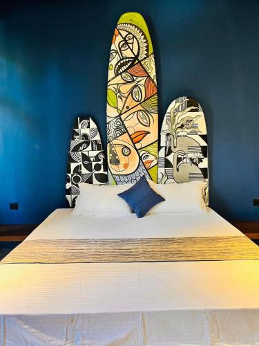 a bedroom with a bed with surfboards on the wall at The Kheak in Weligama