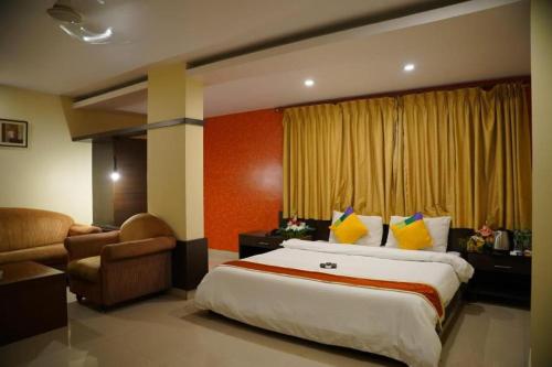 a hotel room with a large bed and a chair at The Road View Grand Hotel & Multi Cuisine Restaurant- 18 Percentage Off On Food Order- An Svm Brand in Hyderabad