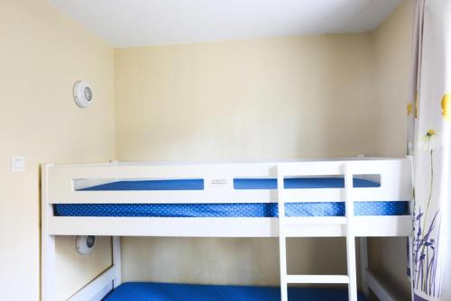 Ce lit superposé se trouve dans une petite chambre dotée de sols bleus. dans l'établissement Résidence le Hameau des Issambres - maeva Home - Studio 5 Personnes Sélection MAE-7938, aux Issambres
