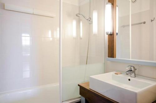 une salle de bain blanche avec un lavabo et une douche dans l'établissement Résidence Port Bourgenay - maeva Home - Appartement 2 Pièces 5 Personnes - Sélection MAE-9029, à Talmont-Saint-Hilaire