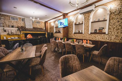 a dining room with tables and chairs and a fireplace at Rodopi Hotel in Haskovo