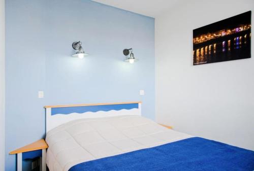 une chambre avec un lit et un tableau au mur dans l'établissement Résidence Port Bourgenay - maeva Home - 2 Pièces 4 Personnes Sélection MAE-9778, à Talmont-Saint-Hilaire