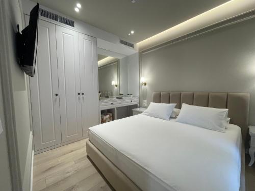 a bedroom with a large white bed and a bathroom at Seaside Hotel in Vlorë