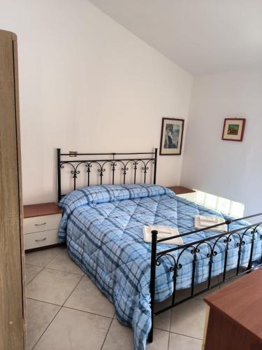 um quarto com uma cama com um edredão azul em B&B MoMa RG Bojano em Boiano