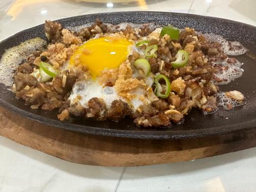 a plate of food with an egg on top at Luckytito Anilao Resort in Mabini