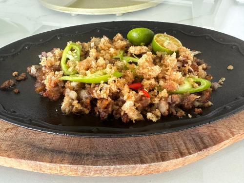 a plate of food with meat and vegetables on a table at Luckytito Anilao Resort in Mabini