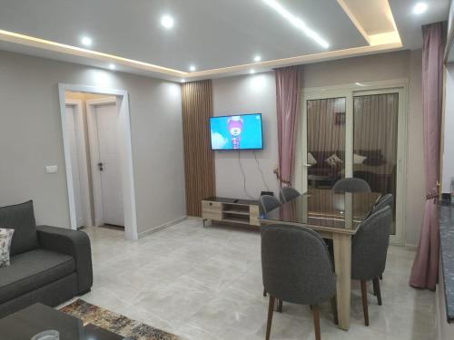 a living room with a table and a tv at المعمورة الشاطئ بالاسكندرية شارع سيف وانلي in Alexandria