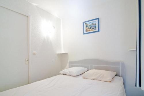 un lit blanc avec deux oreillers dessus dans l'établissement Résidence le Hameau de Cap Esterel - maeva Home - Studio 5 Personnes - Sélection MAE-0154, à Saint-Raphaël