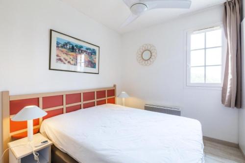 une chambre avec un lit blanc et une fenêtre dans l'établissement Résidence le Village de Cap Esterel - maeva Home - Appartement 4 pièces 8 personnes avec magnifique vue mer - Sélection - Super Home MAE-1481, à Saint-Raphaël