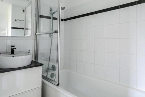 ein weißes Bad mit einem Waschbecken und einer Dusche in der Unterkunft Résidence Port Guillaume - maeva Home - 3 Pièces 6 Personnes Sélection 68 in Dives-sur-Mer