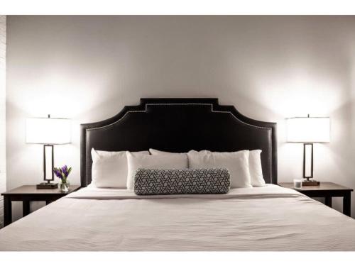 a bed with a black headboard and two lamps at Contemporary 2BR 2BA Apartment by CozySuites in Indianapolis