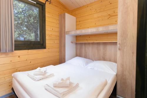 une chambre avec un lit dans une cabane en bois dans l'établissement Feriendorf La Mora, à Calvi